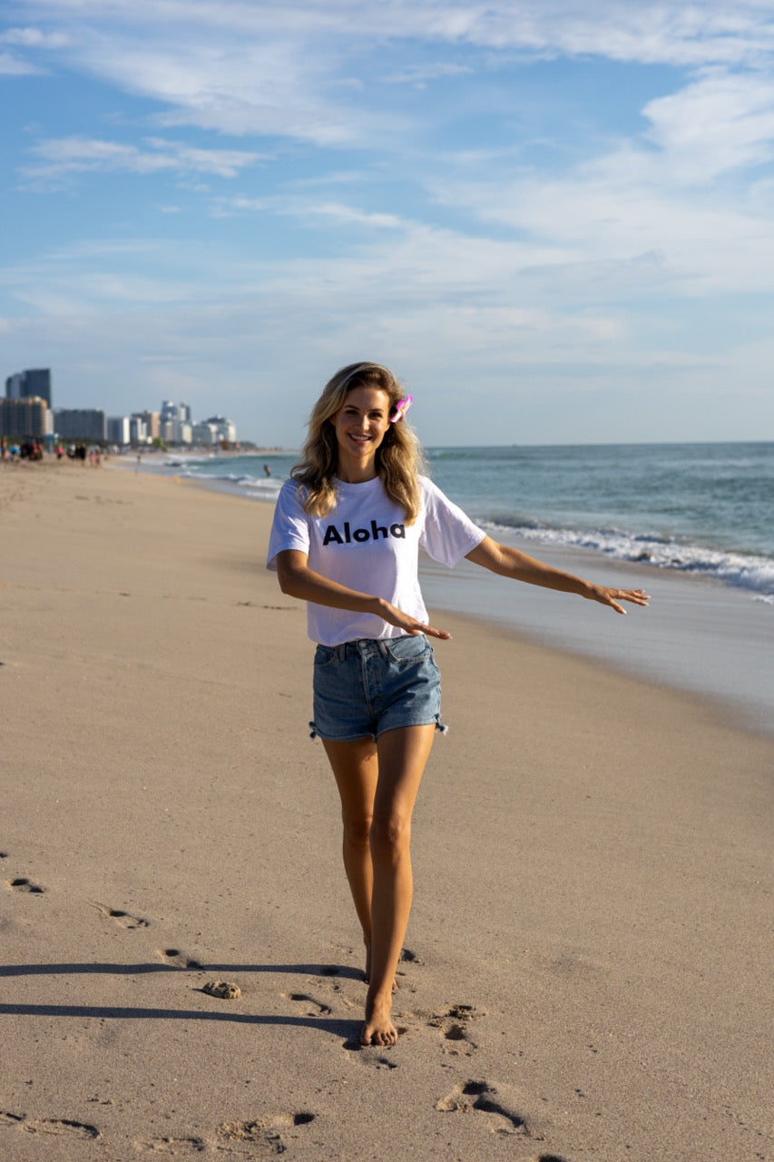 Hi Aloha Hawaiian Greet Tee by Happy interactions in white worn by Claire Schwegman on Miami Beach