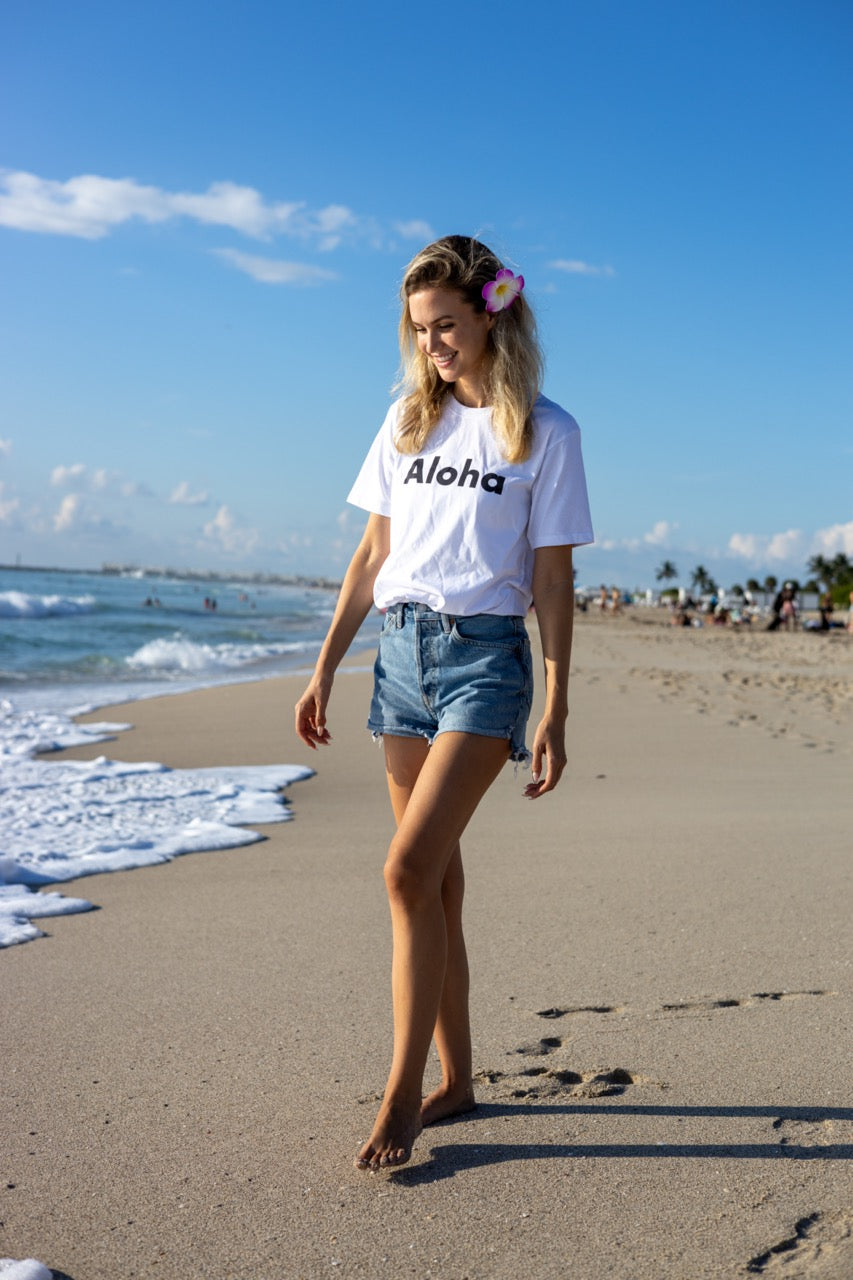 Hi Aloha Hawaiian Greet Tee by Happy interactions in white worn by Claire Schwegman on Miami Beach