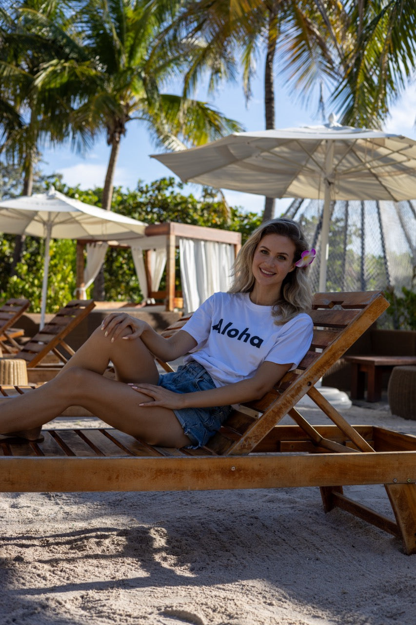 Hi Aloha Hawaiian Greet Tee by Happy interactions in white worn by Claire Schwegman on Miami Beach