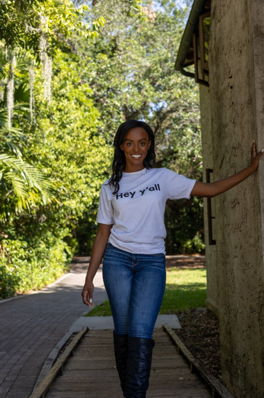Hi Hey y'all Friendly Southern Greeting T shirt in white, modeled by Alyssa Ferguson at the Barnacle in Coconut Grove, Miami Florida