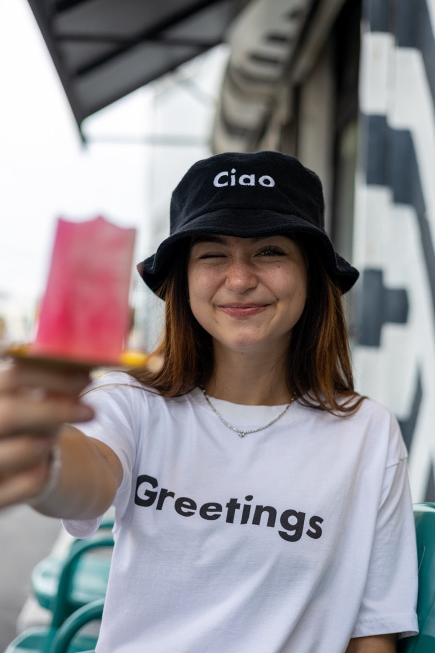 Hi Ciao Terry Towel Beach Bucket Hat in black modeled by Dani Kott in Wynwood, Miami wearing the Greetings T shirt