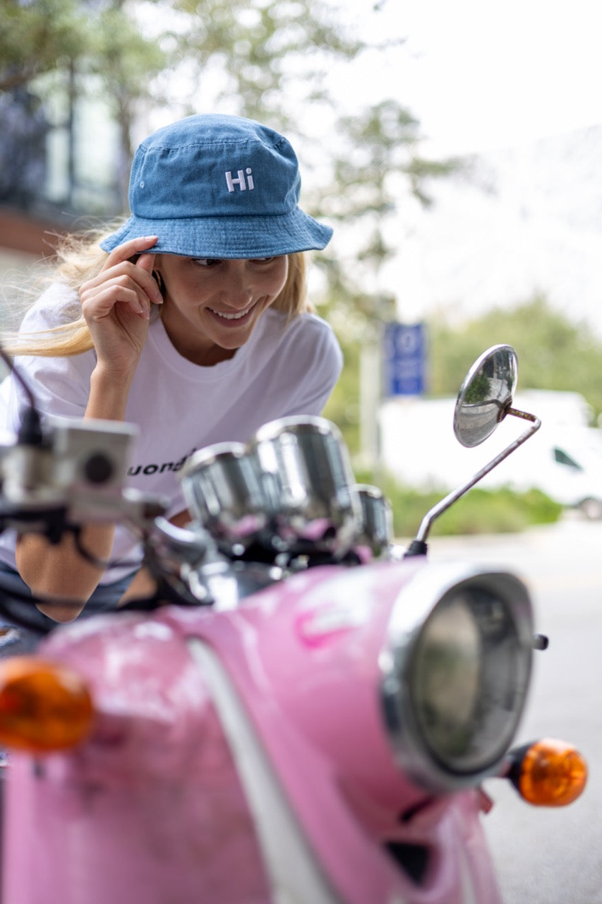 Hi Happy interactions Denim Bucket Hat in Light Blue Denim, modeled by Alia Buoniello in Miami Design District