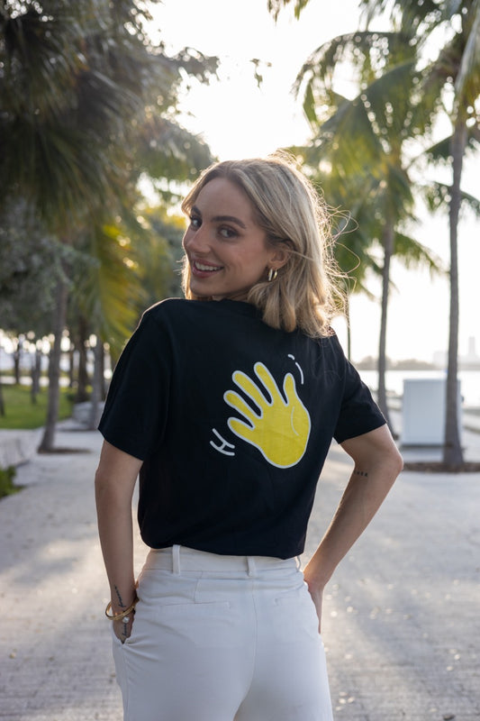 Hi Namaste Indian Greeting T Shirt in black back with Hi waving hand emoji, modeled by Kara Gault photographed by Johnny Michael at Maurice A. Ferré Park in Miami, Florida