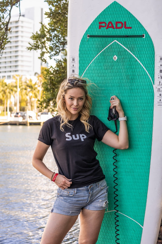 Hi SUP USA Greet Tee by Happy interactions in Black worn by Jen Halvorson on a Stand Up Paddle Board