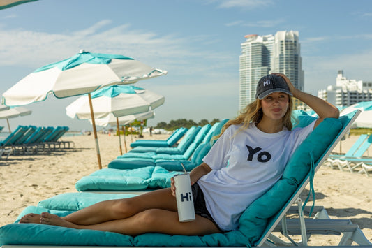 Hi Yo New York Brooklyn Greeting T Shirt in white, modeled by Elli Scarborough along with the Hi tumbler and Hi grey vintage hat