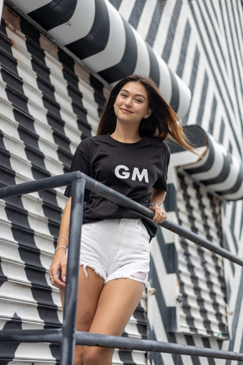 Hi GM Good Morning Internet Lingo Greeting T shirt in black, modeled by Dani Kott in Wynwood, Miami