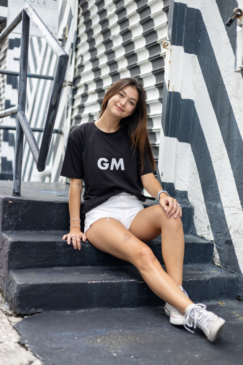 Hi GM Good Morning Internet Lingo Greeting T shirt in black, modeled by Dani Kott in Wynwood, Miami
