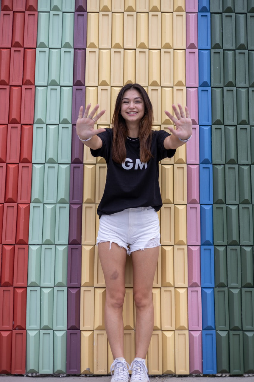 Hi GM Good Morning Internet Lingo Greeting T shirt in black, modeled by Dani Kott in Wynwood, Miami