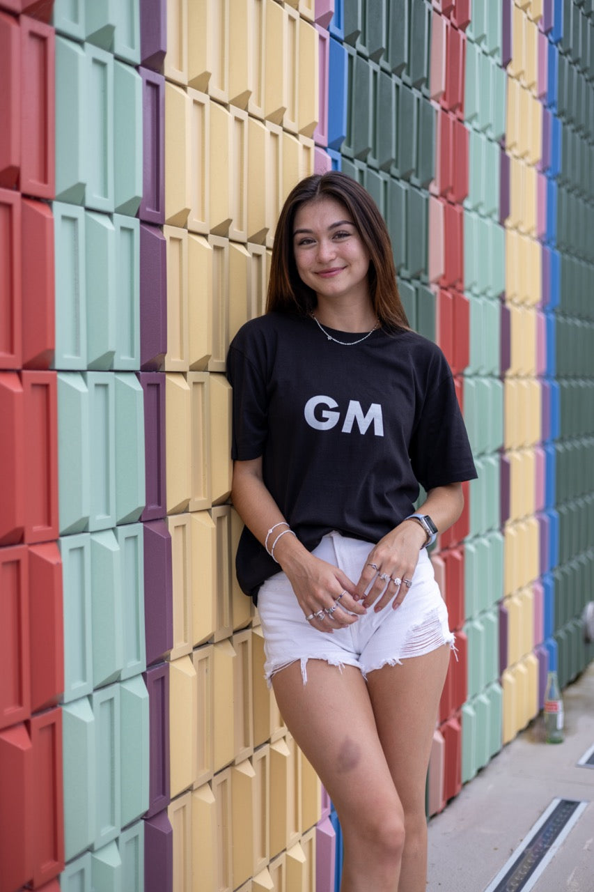Hi GM Good Morning Internet Lingo Greeting T shirt in black, modeled by Dani Kott in Wynwood, Miami