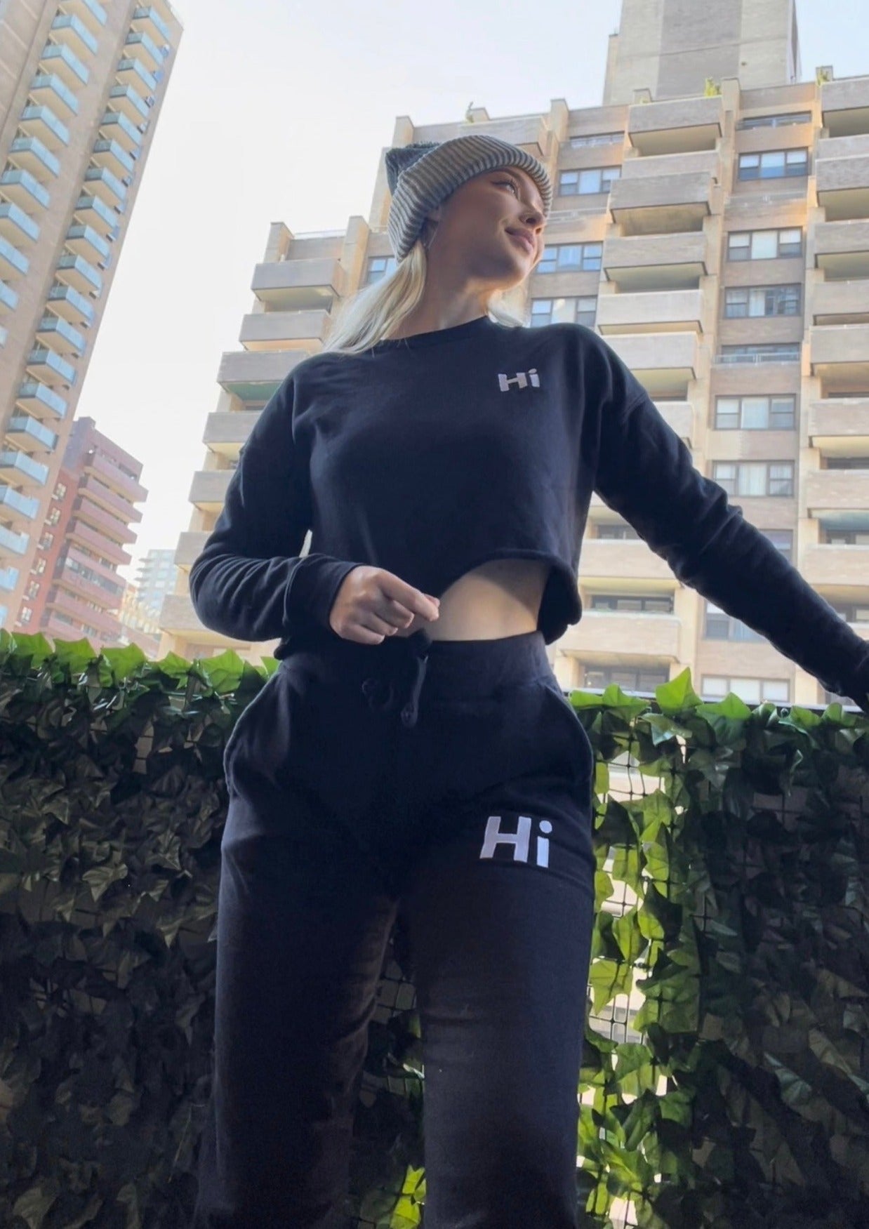 Shannon Milligan models the Hi Cropped Sweatshirt and the Hi Pom Pom Beanie and Hi Sweatpants for Happy interactions.
