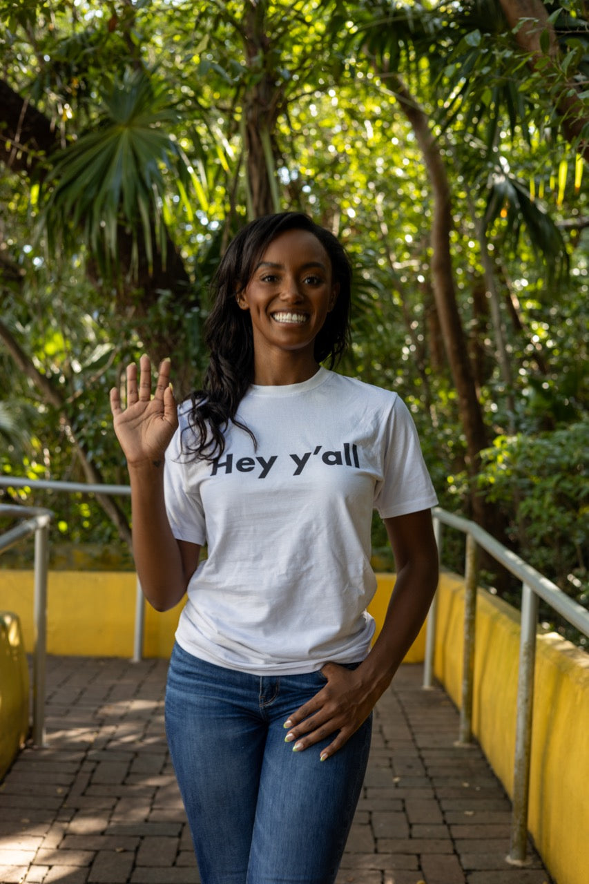 Hi Hey y'all Friendly Southern Greeting T shirt in white, modeled by Alyssa Ferguson at the Barnacle in Coconut Grove, Miami Florida