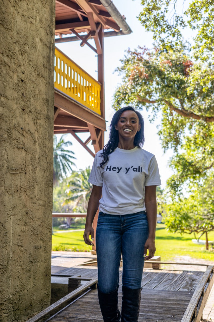 Hi Hey y'all Friendly Southern Greeting T shirt in white, modeled by Alyssa Ferguson at the Barnacle in Coconut Grove, Miami Florida