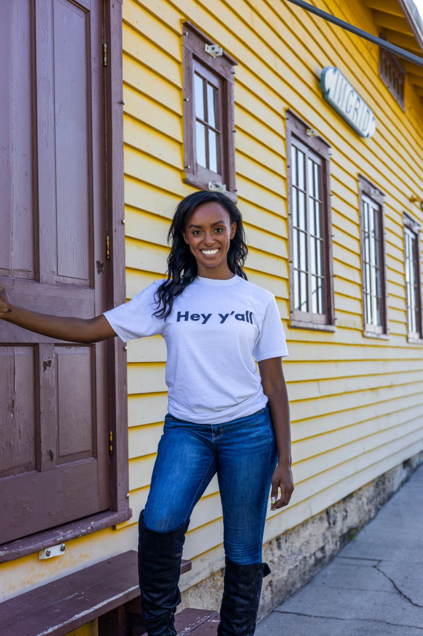 Hi Hey y'all Friendly Southern Greeting T shirt in white, modeled by Alyssa Ferguson at the Barnacle in Coconut Grove, Miami Florida