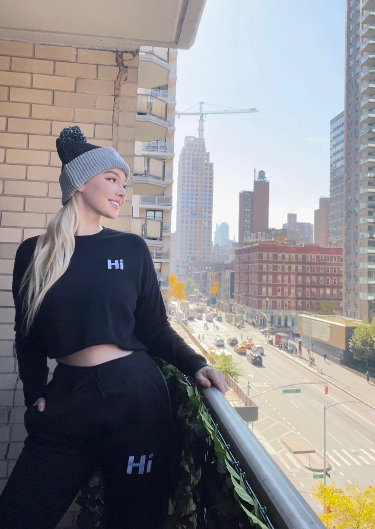 Shannon Milligan models the Hi Cropped Sweatshirt and the Hi Pom Pom Beanie and Hi Sweatpants for Happy interactions.