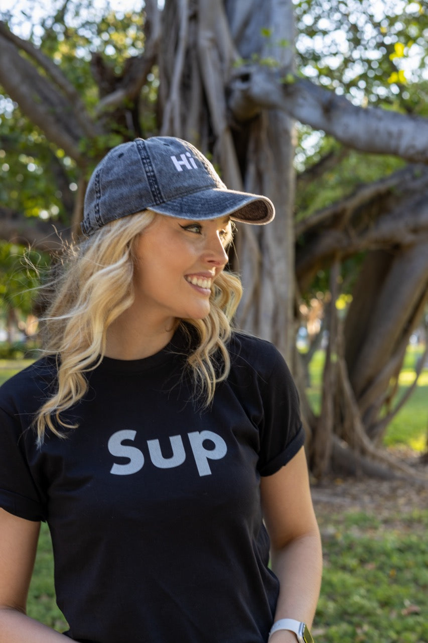 Hi and Yo Vintage Cap in charcoal grey, modeled by Jen Halvorson wearing the Sup Greeting T Shirt