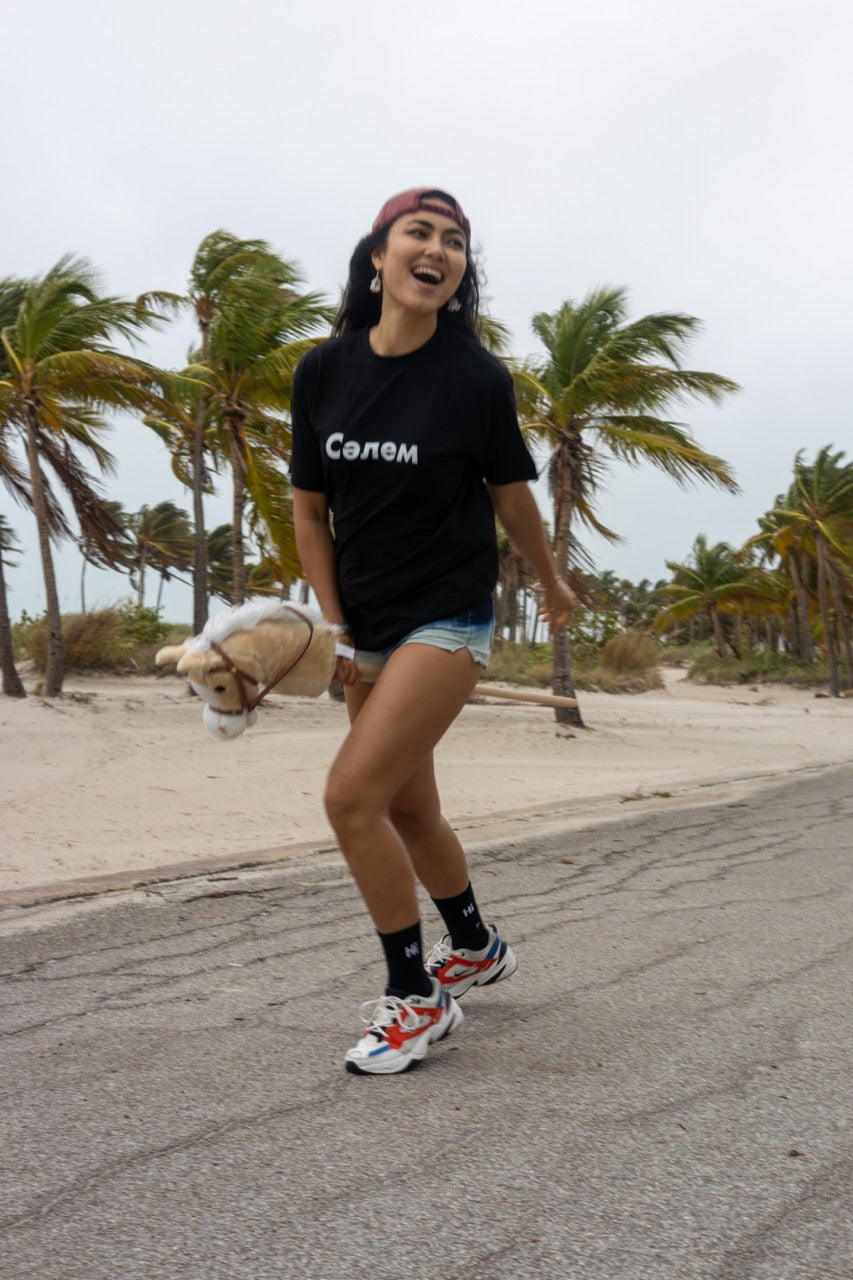 Hi in Kazakh Salem Greeting T Shirt in black, Сәлем written in Cyrillic script is pronounced "Salem", modeled by Assiya Mukanova