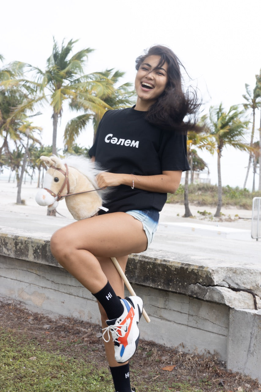 Hi in Kazakh Salem Greeting T Shirt in black, Сәлем written in Cyrillic script is pronounced "Salem", modeled by Assiya Mukanova