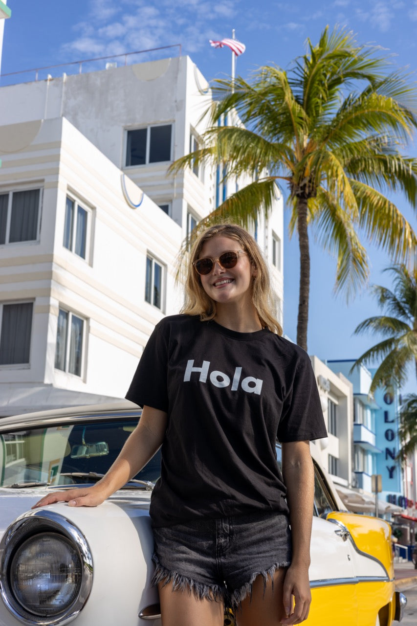 Hi Hola shirt in black modeled by Elli Scarborough on Ocean Drive in Miami Beach