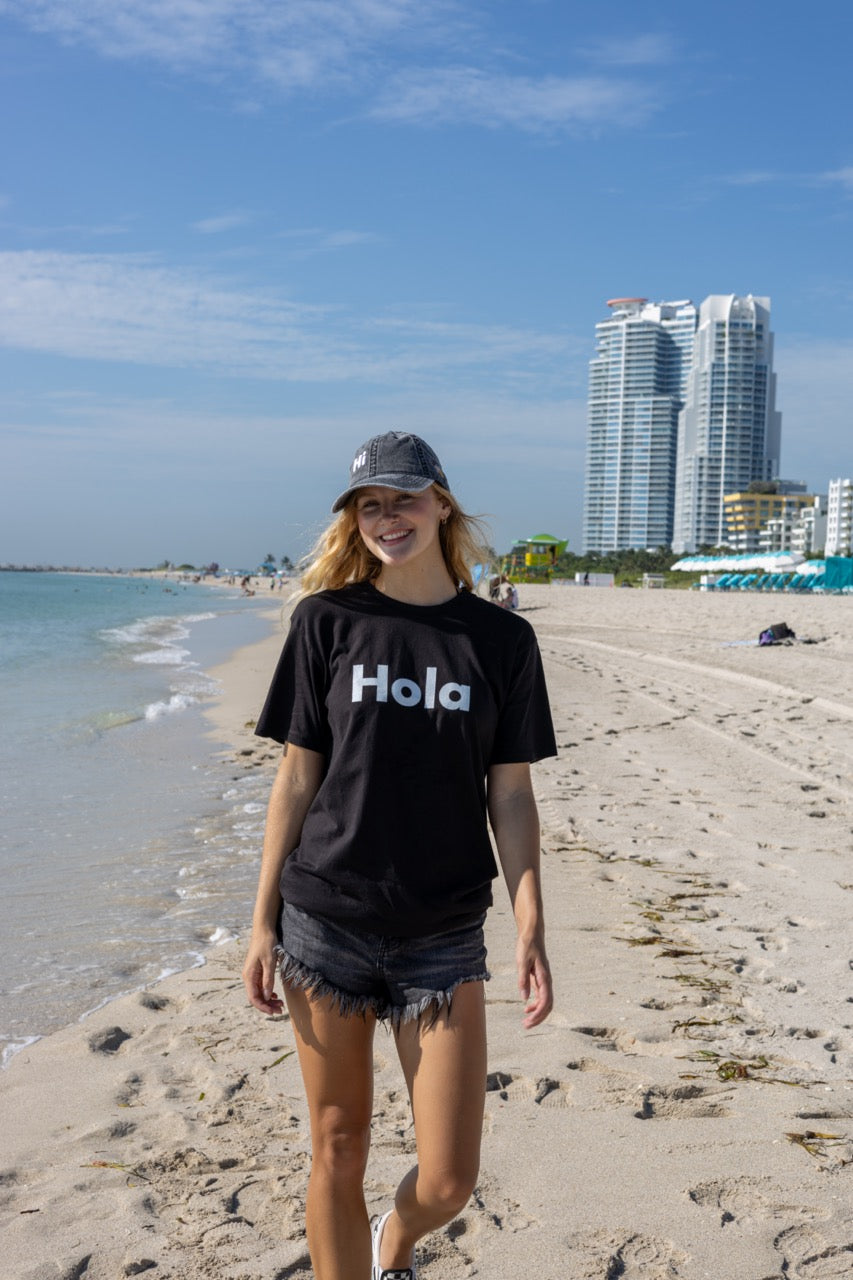Hi Hola shirt in black modeled by Elli Scarborough on Ocean Drive in Miami Beach