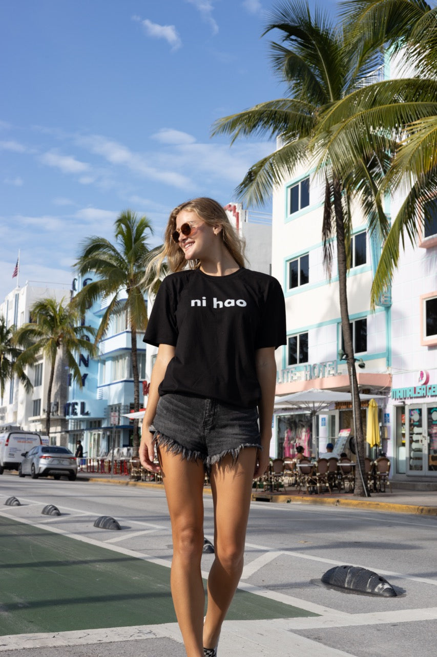 Hi Ni Hao Chinese Greeting T shirt in black, Ni Hao Hi Happy interactions modeled by Elli Scarborough and photography by Johnny Michael in South Beach, Miami