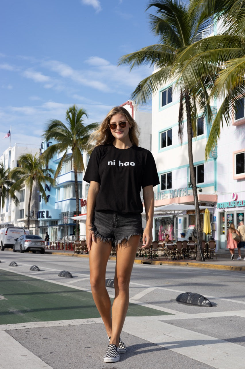 Hi Ni Hao Chinese Greeting T shirt in black, Ni Hao Hi Happy interactions modeled by Elli Scarborough and photography by Johnny Michael in South Beach, Miami