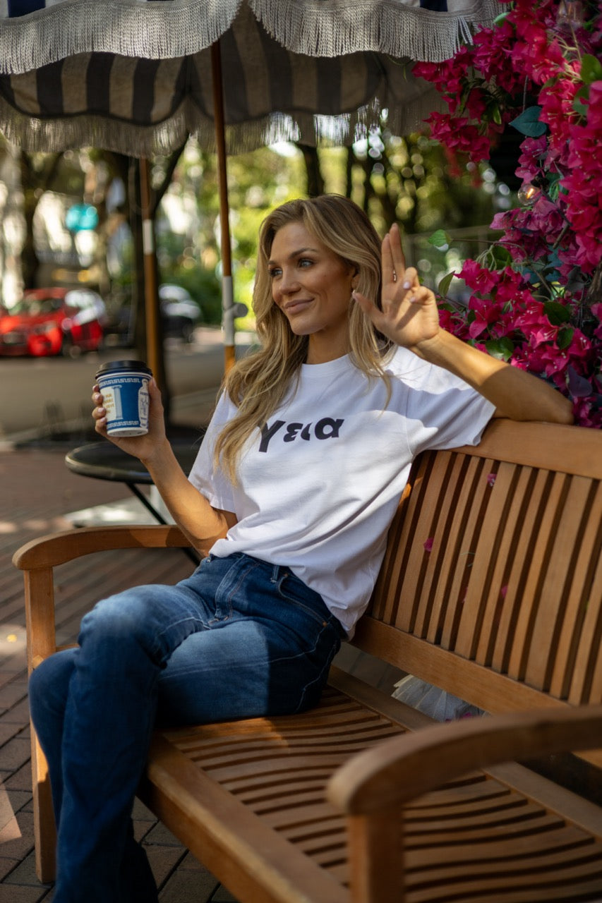 Hi γεια Greek Greet T shirt in white modeled by Victoria Peyton at Calista Cafe in Coconut Grove, Miami Florida, photography by Johnny Michael