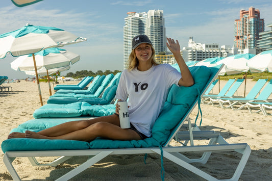 Hi Yo New York Brooklyn Greeting T Shirt in white, modeled by Elli Scarborough along with the Hi tumbler and Hi grey vintage hat