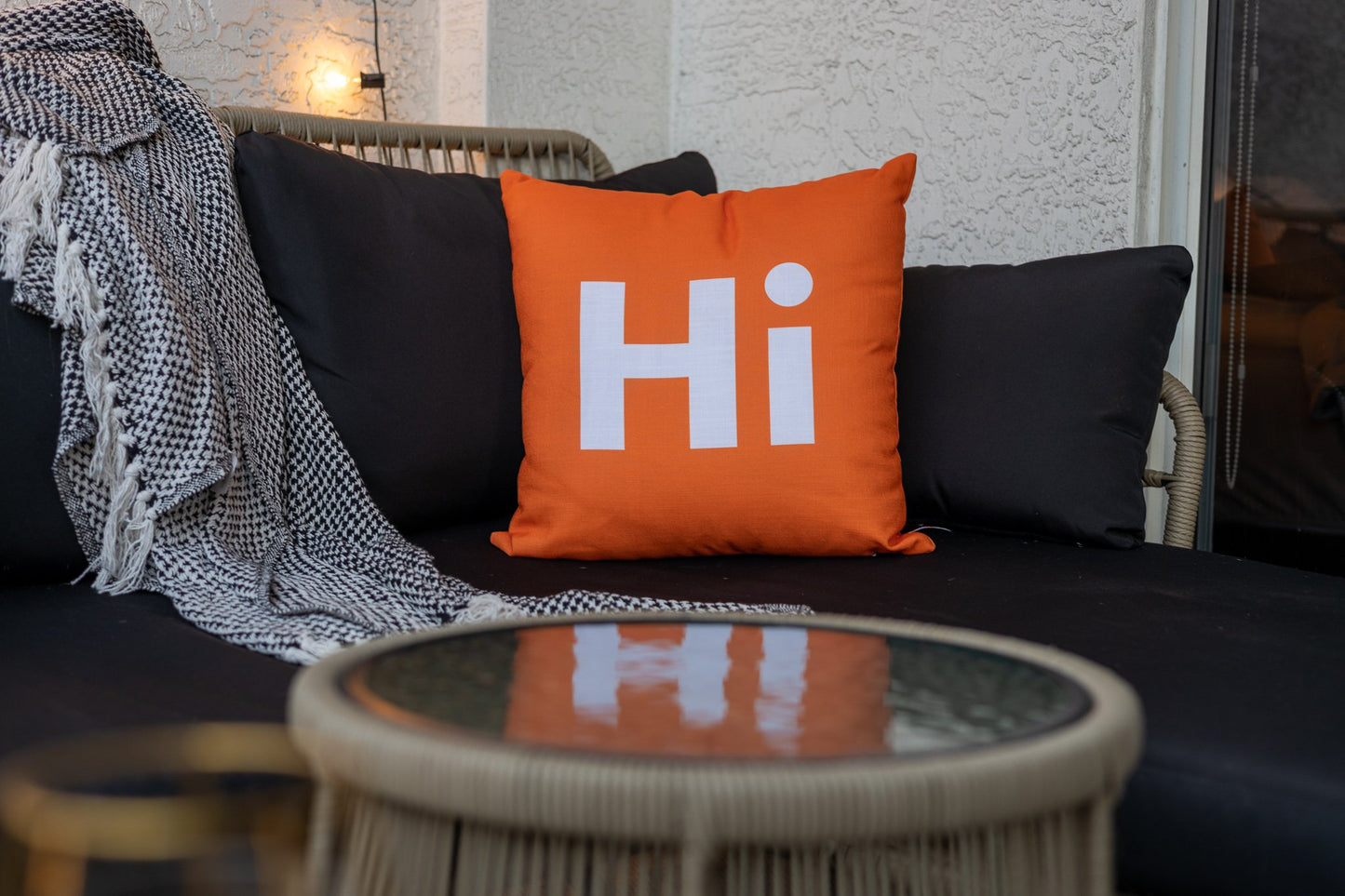 Hi Pillow by Hi Johnny in Hola Orange on a patio balcony