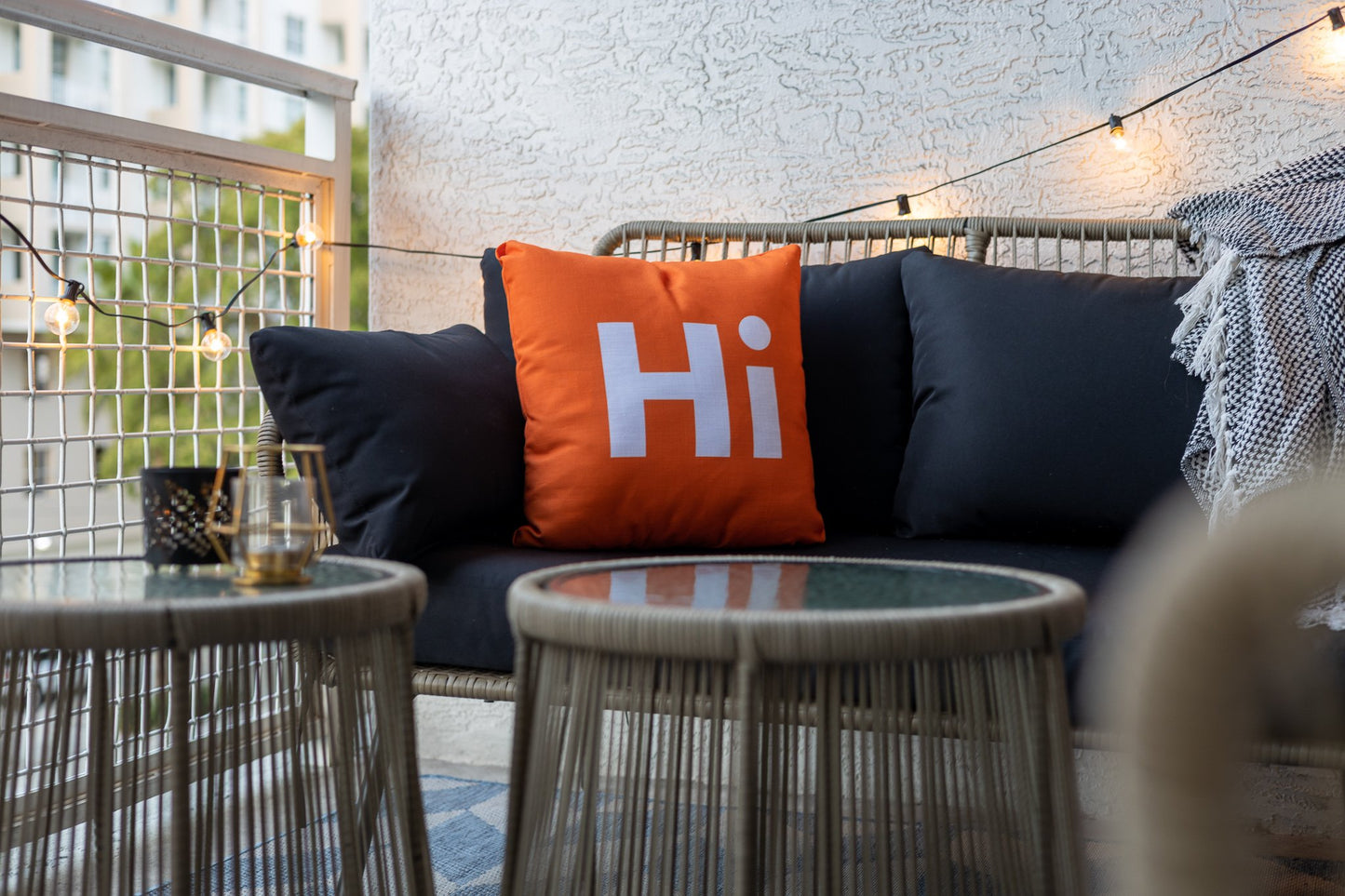 Hi Pillow by Hi Johnny in Hola Orange on a patio balcony